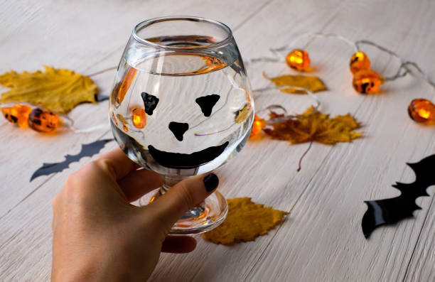 ハロウィーンの背景を持つ手に水のガラス - glass autumn halloween food ストックフォトと画像