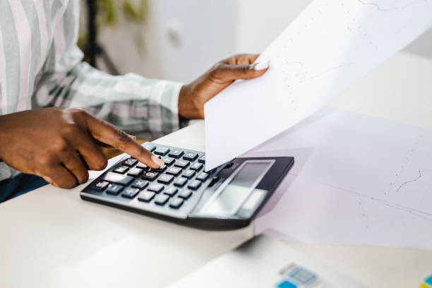 istock Human hand using a calculator and holding a paper 1345885880