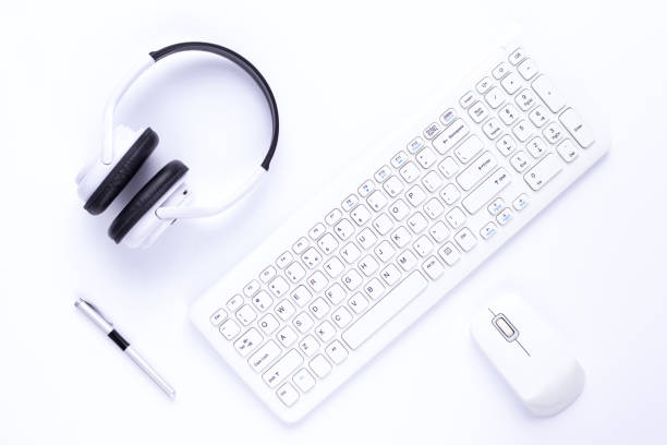 istock Computer keyboard and mouse on white background. Wireless headphones at white 1345886719