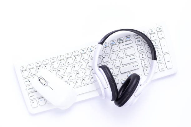 istock Computer keyboard and mouse on white background. Wireless headphones at white 1345886728