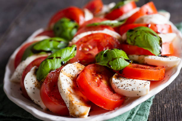 Caprese Salad Classic Caprese Salad with Tomato, Mozzarella, Basil, Olive Oil and Balsamic Vinegar Glaze basil photos stock pictures, royalty-free photos & images