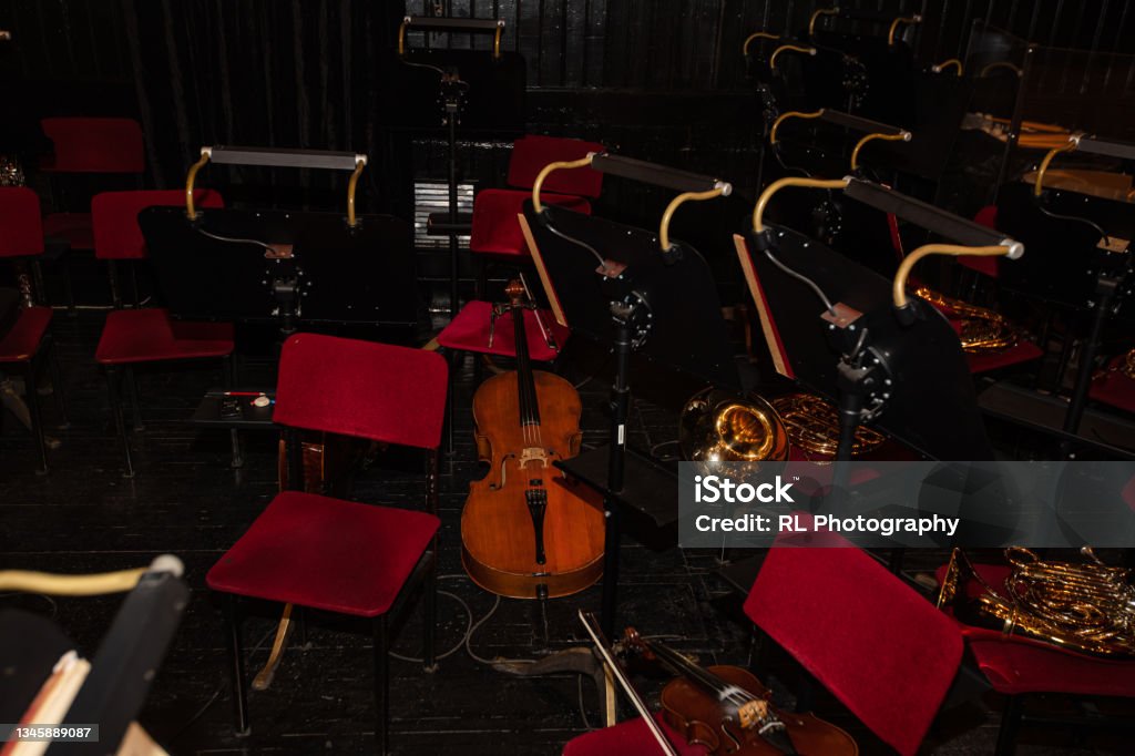 Cello and  French Horn on chair during interval  in theatre Orchestra Pit Stock Photo