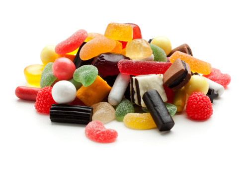 heap of jelly beans, wine gums and liquorice candy isolated on white