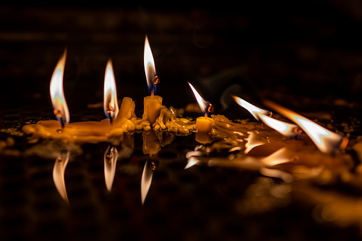 Close up shot of a burning candles and reflection. Tranquility and religion illustration concept