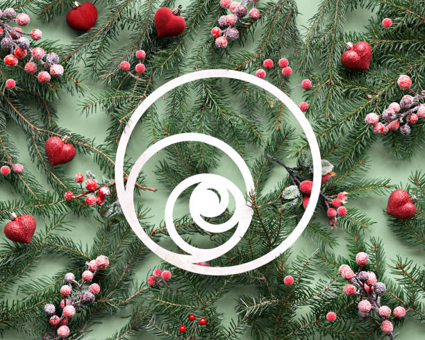 Green red Christmas background with Fibonacci sequence circles as central element. Natural Xmas twigs decorated with frosted berries and red heart trinkets. Flat lay. top view on green paper