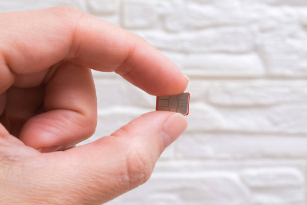 istock Fingers holding a micro sim card for mobile communication close up 1345895403
