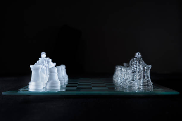 istock crystal chess pieces on a glass board on black background with copy space 1345896089