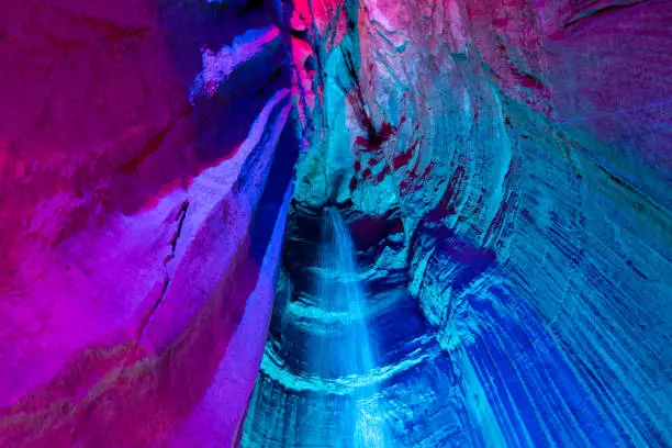 Blue and purple lights shown lighting up the Ruby Falls Cave tourist attraction in Chattanooga, Tennessee in mountains.