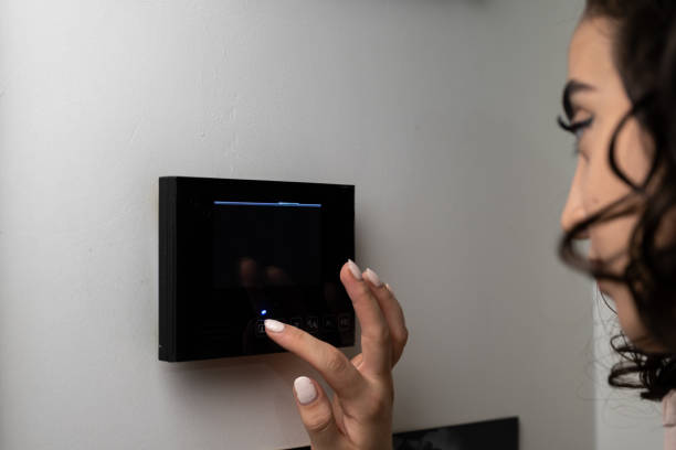 istock woman controlling the door with smart home systems 1345897214
