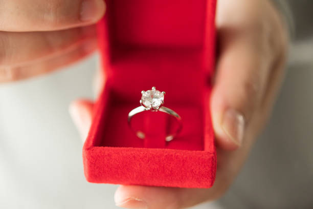 istock hands holding diamond ring in jewelry box 1345902070
