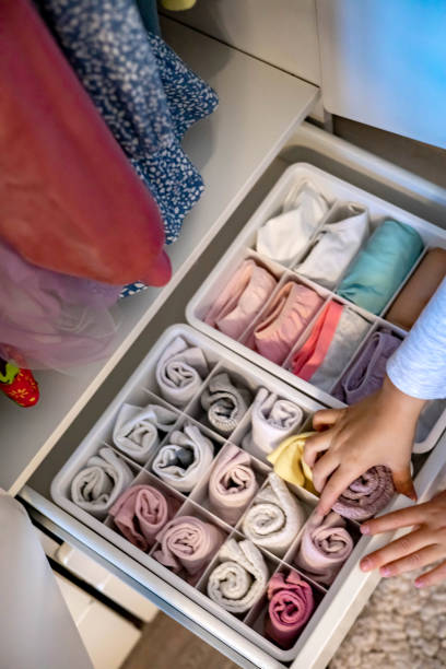 istock Female hands organizing storage of underwear socks t shirts use Marie Kondo's method. Perfectionist Teenage girl 1345902425