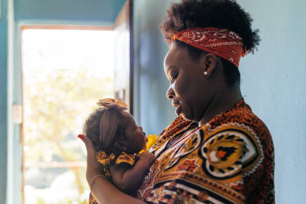 африканская мать держит ребенка на коленях - developing countries фотографии стоковы�е фото и изображения