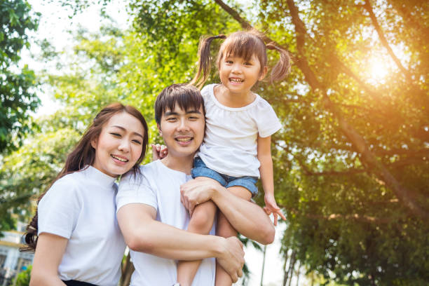 Happy Asian family in public park stock photo