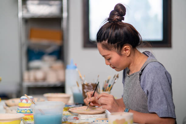 istock Asian woman enjoy painting self-made pottery at pottery workshop studio. 1345924498