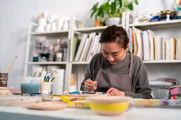 istock Asian woman enjoy painting self-made pottery at pottery workshop studio. 1345924499