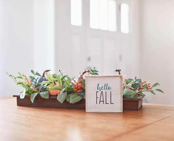 istock Thanksgiving Fall Decoration with Pumpkins and Hello Fall Message on Dining Room Table 1345925933