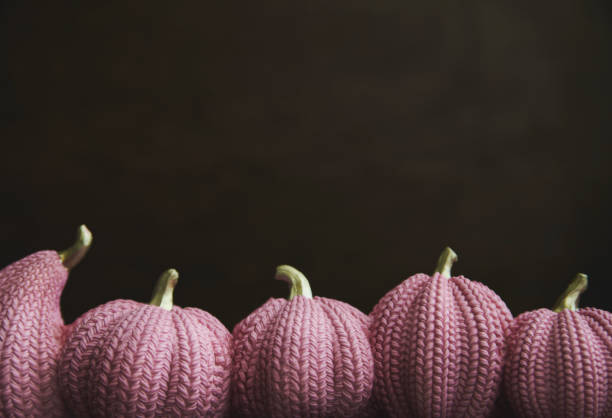 Cute crochet knitted yellow pumpkin on white background with a ball of yarn and a hook copy space