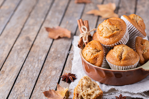 Comfort food. Homemade autumn cakes or muffins with nuts and spices on a wooden table. Autumn or fall baked pastry. Copy space background