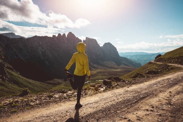 istock Woman ultramarathon runner stretching legs while running at mountain top 1345929751
