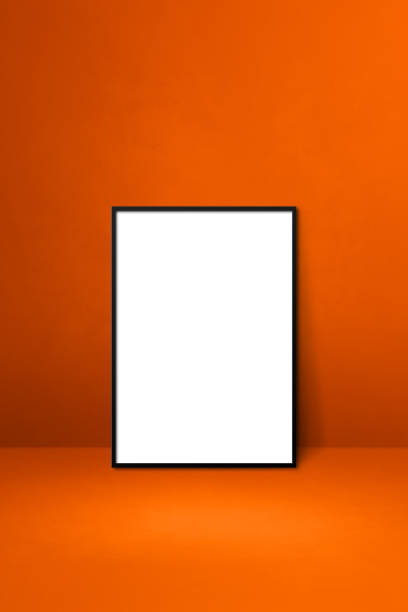 istock Black picture frame leaning on an orange wall 1345932969