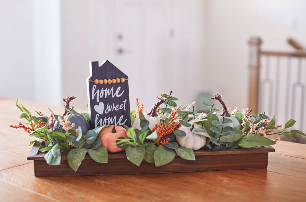 istock Fall Arrangement in Bright Modern Home Interior with Pumpkins and Home Sweet Home Message 1345933041