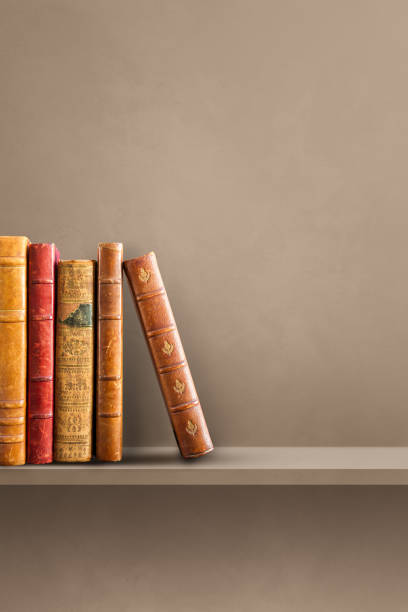 istock Row of old books on brown shelf. Vertical background 1345933455