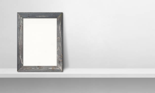 istock Wooden picture frame leaning on a white shelf. 3d illustration. Horizontal banner 1345933509