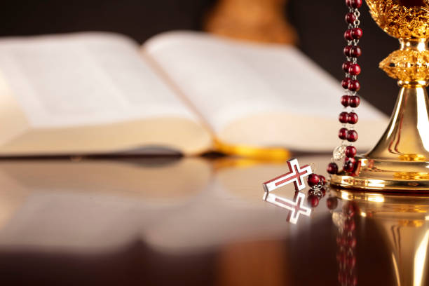 Jesus figure,The Cross, monstrance,  Holy Bible and golden chalice on the gray background.