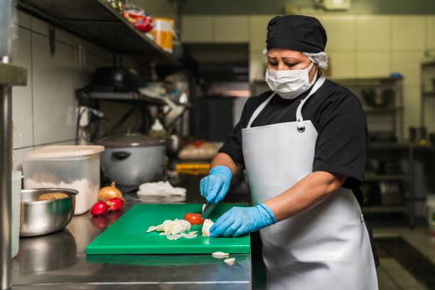 istock Professional cook cutting onions on a plastic board at kitchen of restaurant 1345934534