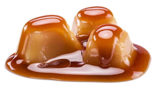 istock Caramel candies covered with melted sugar caramel isolated on white background. 1345935388