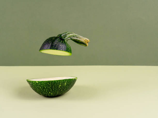 istock Two pieces of zucchini on a green background. 1345935563