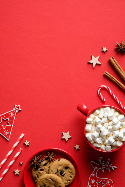 Christmas food and decorations on red background. Flat lay hot cocoa with marshmallows, oatmeal cookies, candy canes, cinnamon sticks. Christmas food and decorations on red background. Flat lay hot cocoa with marshmallows, oatmeal cookies, candy canes, cinnamon sticks. hot chocolate photos stock pictures, royalty-free photos & images