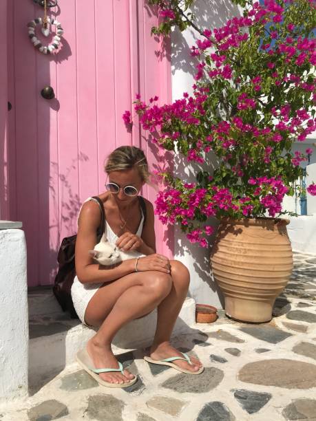 istock Young woman cuddling stray cat in Greece 1345935702