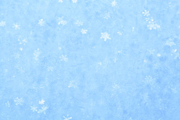 Blue sparkling snow background with white little snowflakes.