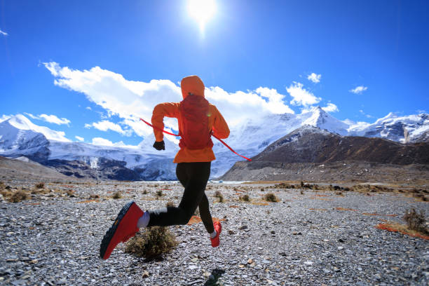 mulher trail runner cross country correndo em alta altitude natureza inverno - exploration mountain ice jumping - fotografias e filmes do acervo
