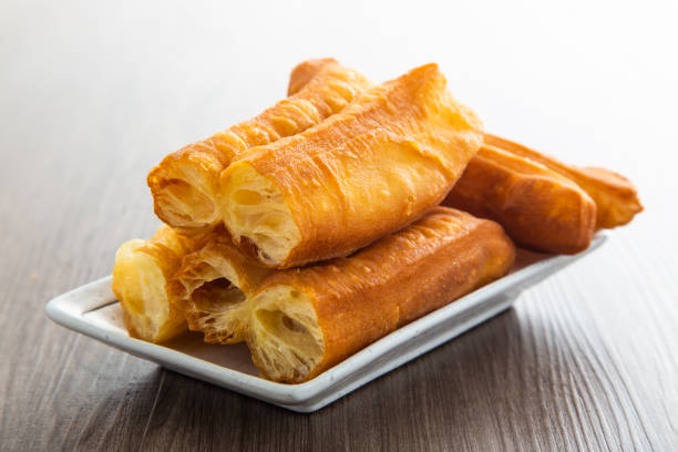 Youtiao (Chinese fried breadstick). Long golden brown deep fried dough strip. Youtiao (Chinese fried breadstick). Long golden brown deep fried dough strip. traditional malaysian food stock pictures, royalty-free photos & images