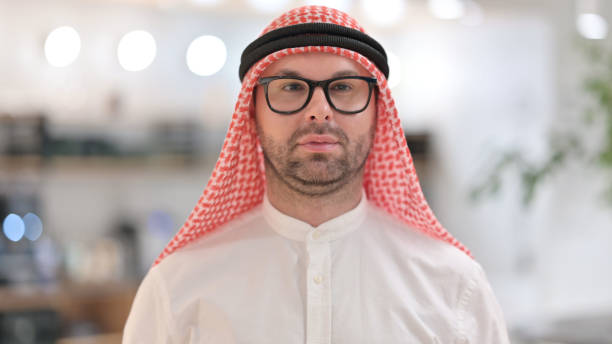 istock Portrait of Serious Young Arab Man Looking at Camera 1345941057