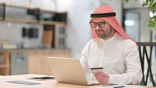 istock Successful Online Payment by Young Arab Man 1345941370