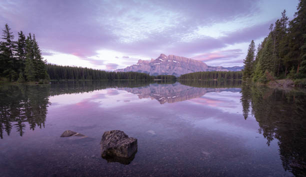 istock Peaceful colorful sunrise with dominant mountain reflecting on still lake´  s surface 1345942313