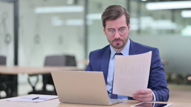 istock Businessman working on Laptop with Documents in Office 1345942475