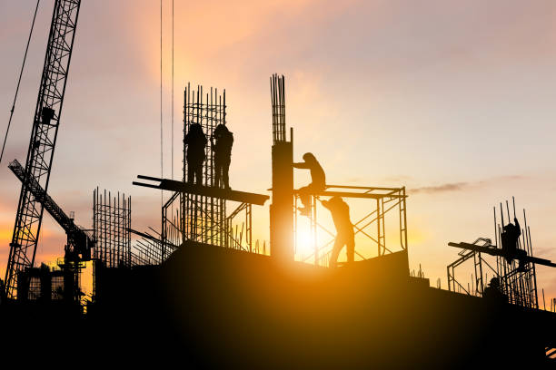 istock Silhouette of worker team on building site, construction site at sunset in evening time 1345943645