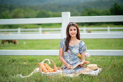 Young woman sitting on a picnic blanket at the public park