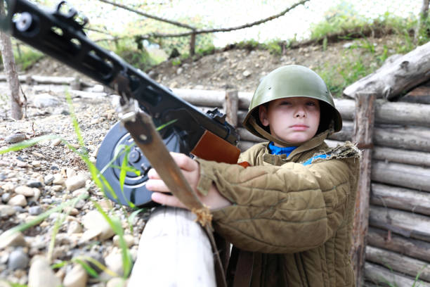 istock Kid with PPSh-41 submachine gun in trench 1345947644
