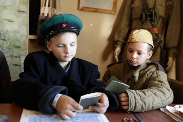 istock Kids in uniform of red army with document 1345948645