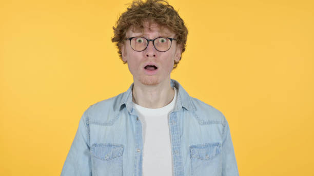istock Redhead Young Man Feeling Shocked on Yellow Background 1345949197