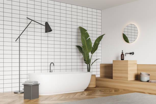 istock Corner view on bathroom interior with bathtub and round mirror 1345950178