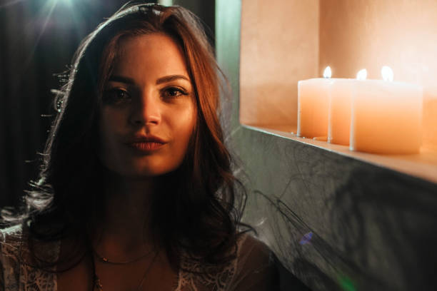 istock Aromatherapy. A brunette in underwear extinguishes candles before bedtime. Romantic setting on Valentine's Day 1345950910