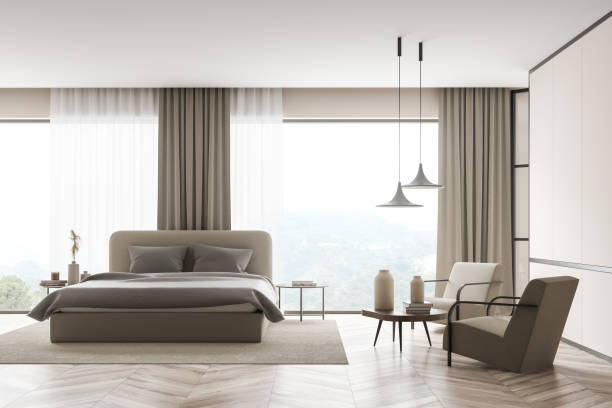 istock Modern beige bedroom with panoramic windows and seating area 1345951625