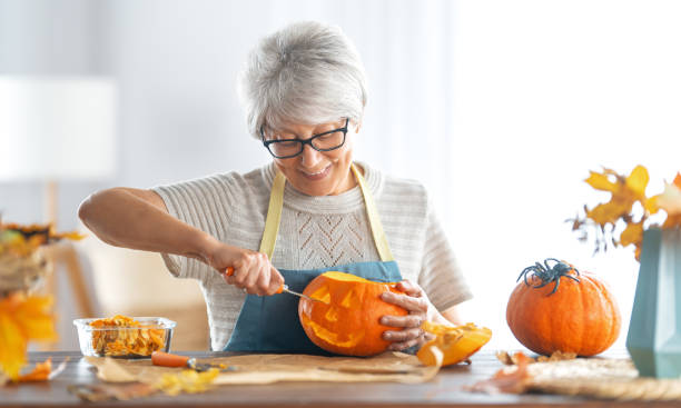 istock woman is carving pumpkin 1345951705
