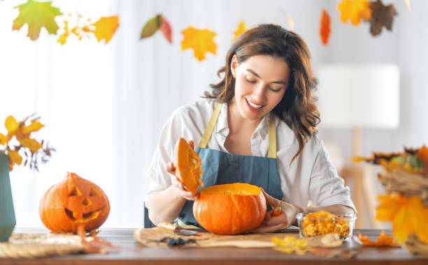 istock woman is carving pumpkin 1345951873